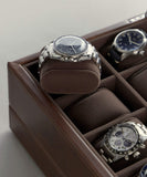 The TAWBURY Bayswater Watch Box Pillows in Brown/Grey (50mm, Small) offers a sophisticated rotating display with three silver wristwatches on plush pillows, one stylishly elevated for customisable watch storage.