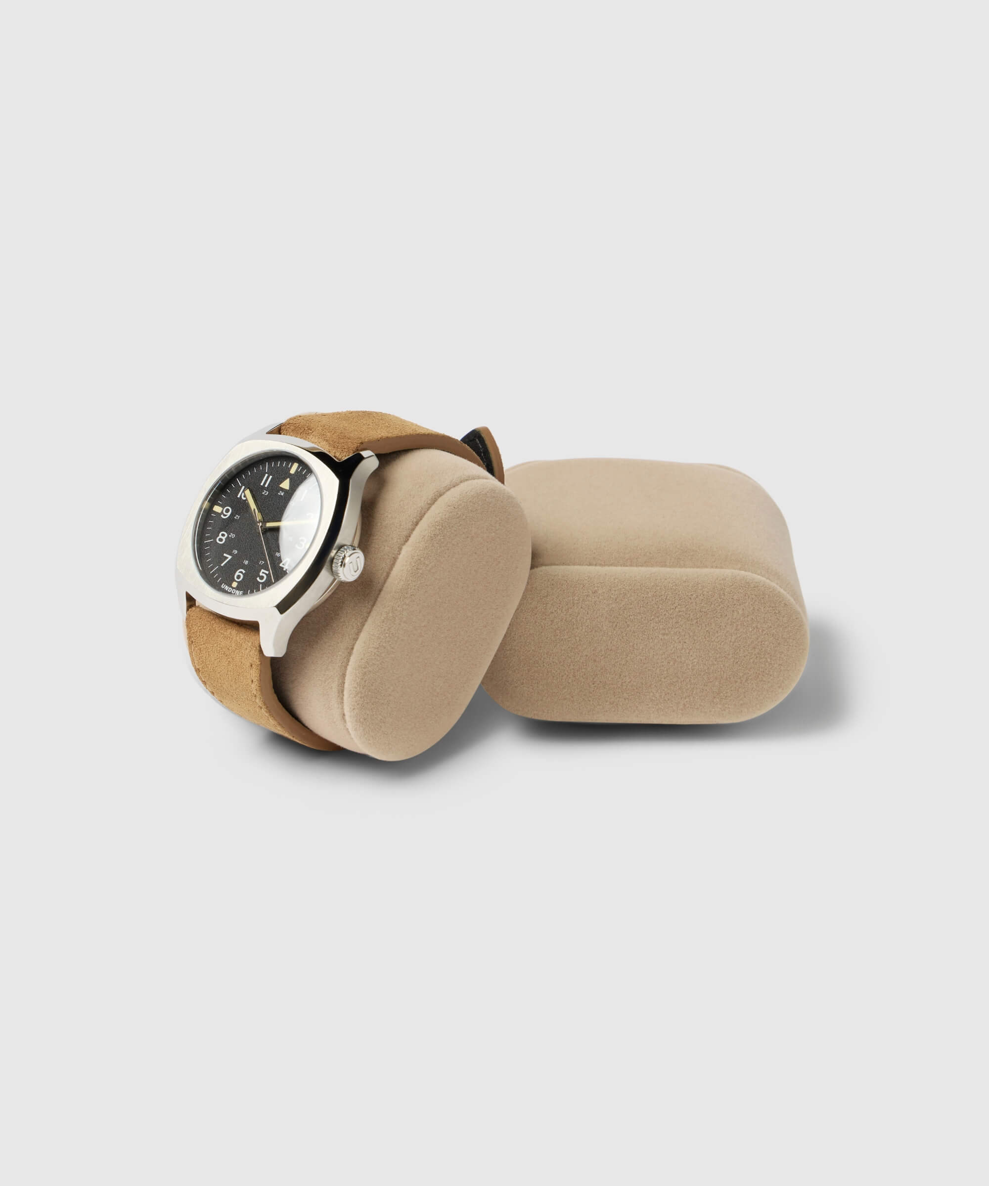 A TAWBURY wristwatch with a black dial and silver casing is displayed on a beige Bayswater Watch Box Pillow - 50mm - X-Small, inside the box with an additional empty pillow.