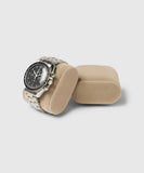 A Bayswater Watch Box Pillow (55mm, Small) in beige by TAWBURY displays a silver watch with a black dial elegantly on its soft velveteen fabric against a simple light background.