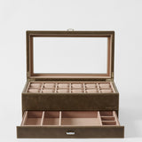 The TAWBURY Bayswater 12 Slot Watch Box with Storage in Driftwood Taupe offers a glass lid, upper watch compartments, and a lower drawer for additional accessories.