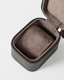The TAWBURY Fraser 1 Watch Case - Brown features a textured leather exterior, zippered closure, and a soft cushioned insert—partially open to show the interior—making it ideal for elegant watch storage while traveling.