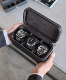 A person holding the Fraser 3 Watch Travel Case - Black by TAWBURY, featuring a secure closure with a zipper to keep your watches protected at all times.
