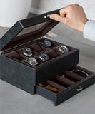 A person opens the chic Bayswater 8 Slot Watch Box by TAWBURY, an essential for collectors. It displays six elegant timepieces in the top compartment, while a PU leather-lined drawer below neatly stores watch bands and accessories.