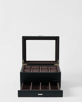 The TAWBURY Bayswater 8 Slot Watch Box with Storage in Black/Charcoal features a glass lid for elegant display, multiple watch compartments, and extra space in a convenient pull-out drawer below.