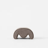 The TAWBURY Grove Watch Pillows - X-Small in brown, designed for slender wristwatches with a curved wave-like cutout, is shown on a plain white background.