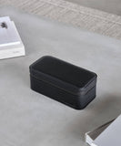 A Fraser 3 Watch Travel Case - Black by TAWBURY sitting on a table next to a laptop.