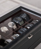The TAWBURY Bayswater 24 Slot Watch Box with Drawer in black PU leather and charcoal interior features a glass lid and organizes up to 24 wristwatches elegantly in separate compartments.