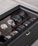 The TAWBURY Bayswater 12 Slot Watch Box elegantly displays watches on a refined charcoal interior in two rows, featuring both metal and rubber straps beneath its glass top.