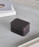 A TAWBURY Fraser 2 Watch Travel Case - Brown, a small leather box designed for watch lovers, elegantly sits on a table next to a book.