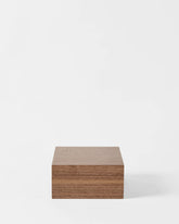 The TAWBURY Grove 6 Slot Wooden Watch Box in light walnut features a solid lid and compact rectangular design—a stylish way to organize your collection against a clean, white backdrop.