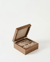 The TAWBURY Grove 6 Slot Wooden Watch Box features a solid light walnut lid and offers elegant storage for six watches, each in its own cushioned compartment lined with beige fabric.