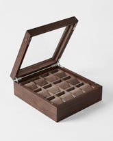 The TAWBURY Grove 12 Slot Wooden Watch Box in dark walnut features a glass lid and brown fabric lining, providing an elegant way to display and store your cherished watches.