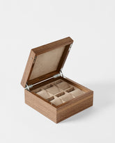 The TAWBURY Grove 6 Slot Wooden Watch Box in light walnut features a solid lid, six compartments with beige fabric lining, and matching cushion inserts for elegant watch storage.