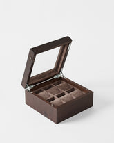 The TAWBURY Grove 6 Slot Wooden Watch Box in Dark Walnut features a glass lid and multiple brown padded compartments—ideal for storing watches or organizing jewelry in a stylish, elegant box.