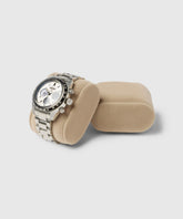 The TAWBURY Bayswater stainless steel watch with a silver band and round face elegantly rests on a beige Bayswater Watch Box Pillow, complemented by slender wrist pillows.