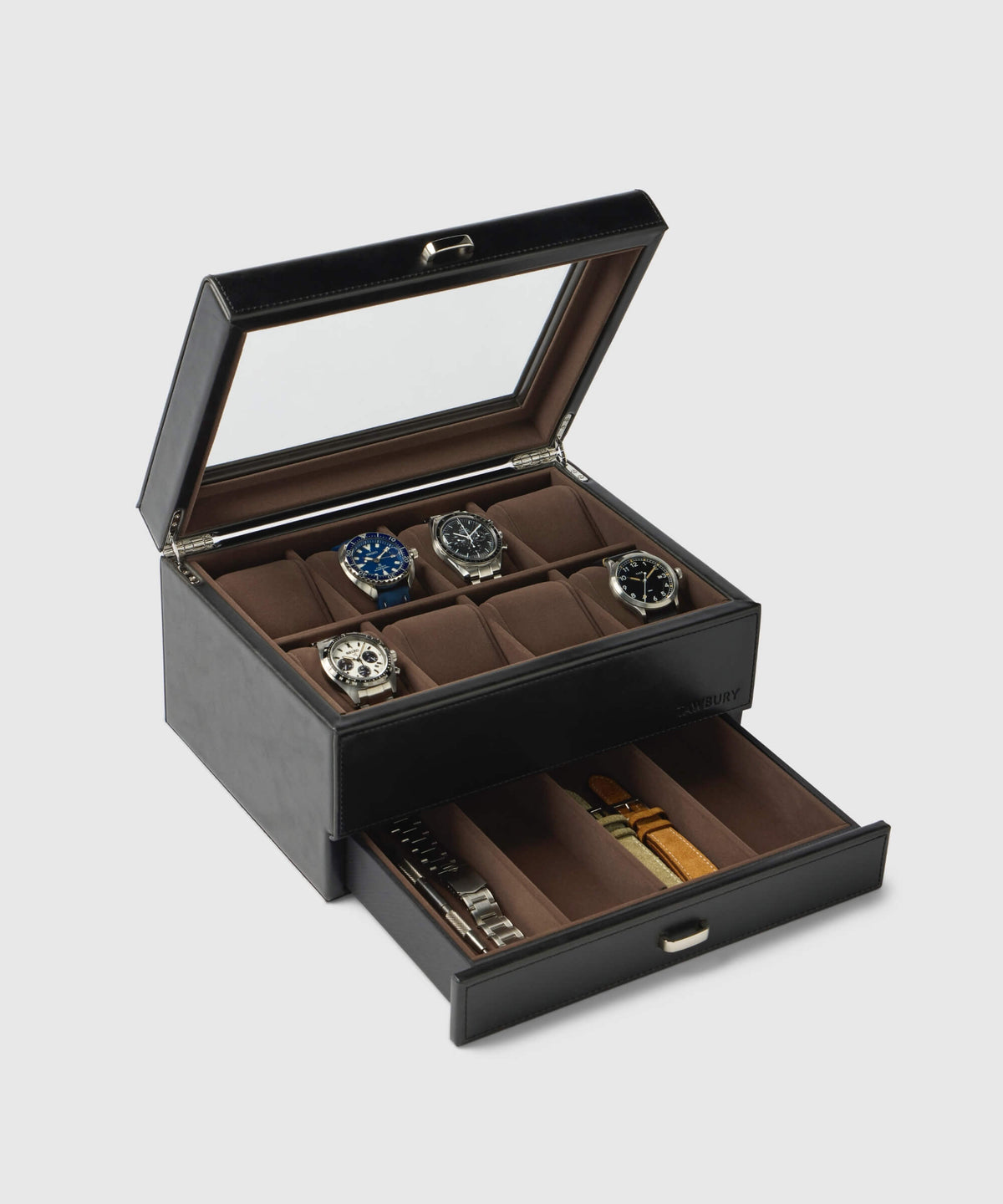 Opening the Bayswater 8 Slot Watch Box with Storage in black by TAWBURY reveals four wristwatches comfortably arranged in a plush, scratch-free interior beneath a glass lid. Below, a drawer holds interchangeable watch straps made from luxurious vegan leather.