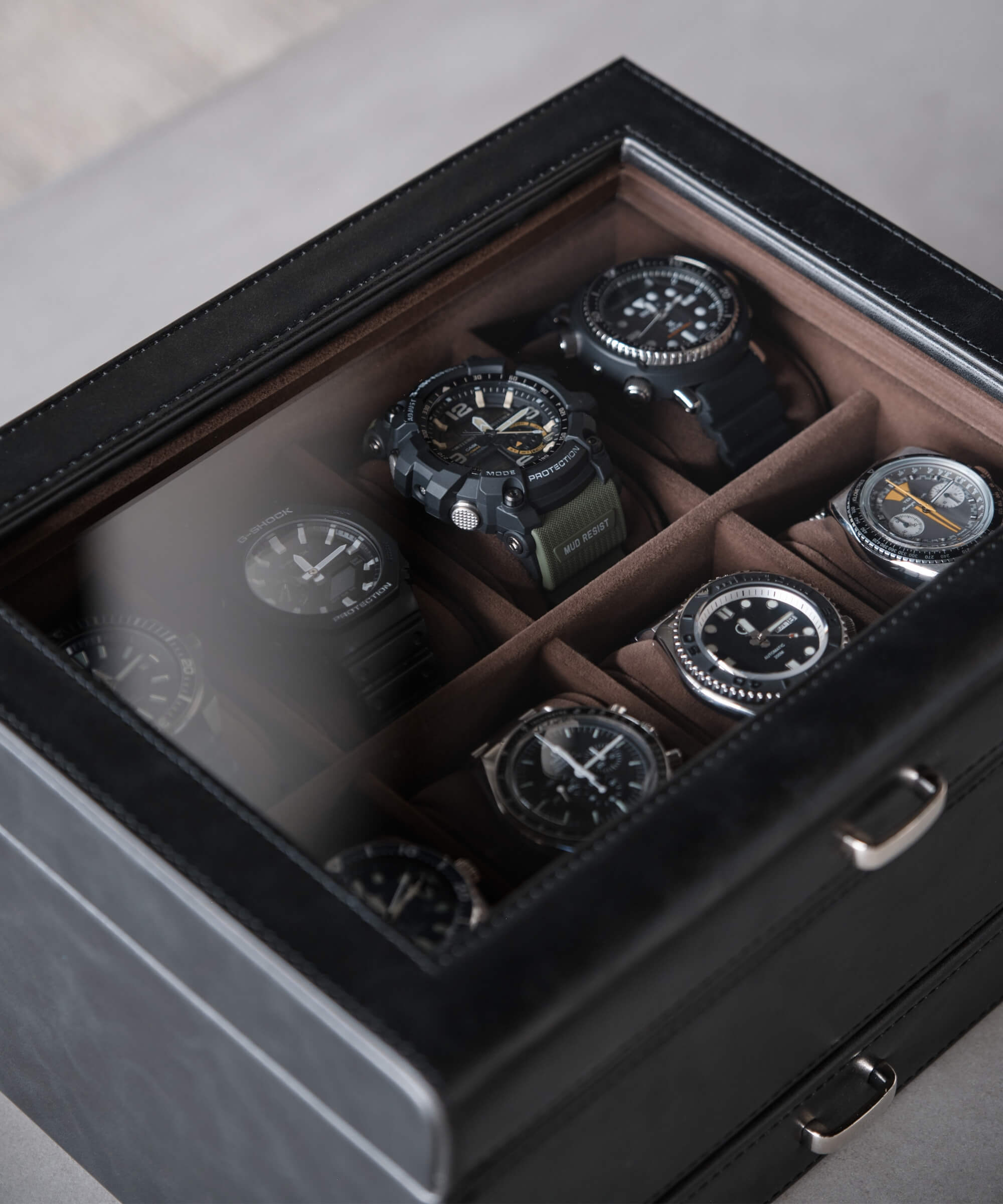 An Tawbury Bayswater 8 Slot Watch Box with Drawer - Black organizer watch case with several watches in it, made from vegan leather.