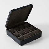 TAWBURY Fraser 12 Watch Case - Midnight Black: a black leather watch box with a hinged lid, featuring twelve interior compartments with brown velvet cushions for watch storage.