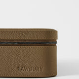 Close-up of a TAWBURY Fraser 3 Watch Case with Storage - Truffle Taupe, featuring a taupe leather exterior with a zippered closure and an embossed logo on the side.