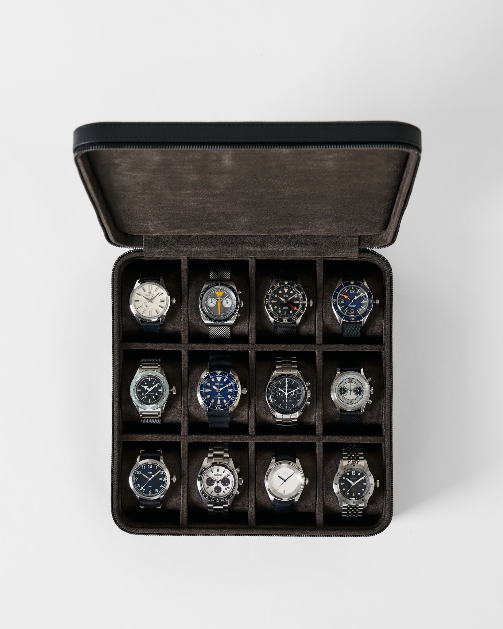 Open midnight black TAWBURY Fraser 12 Watch Case with twelve individual compartments, each containing a different analog wristwatch.