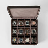 An open TAWBURY Fraser 12 Watch Case - Espresso Brown with twelve individual compartments, each containing a different luxury wristwatch.