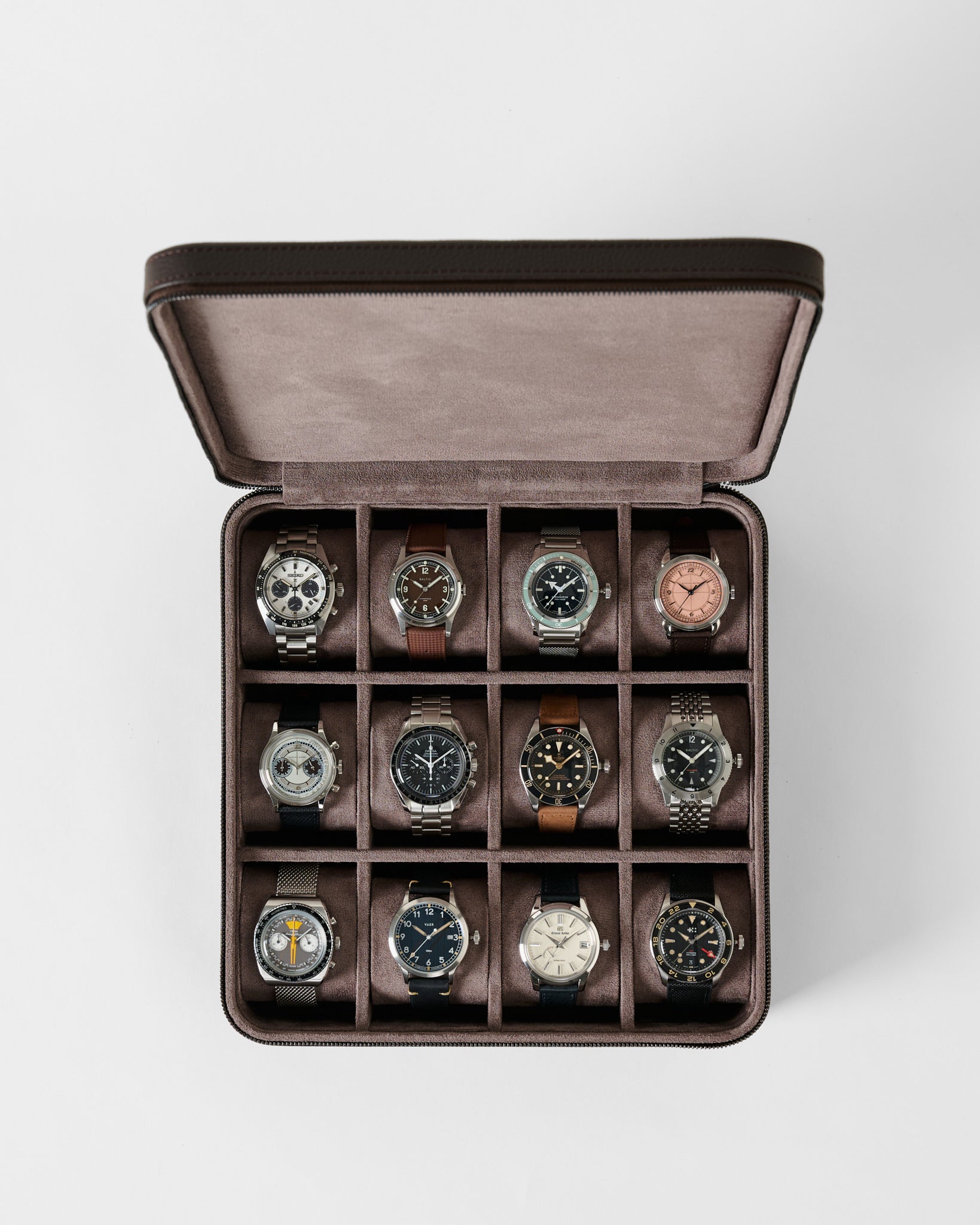 An open TAWBURY Fraser 12 Watch Case - Espresso Brown with twelve individual compartments, each containing a different luxury wristwatch.