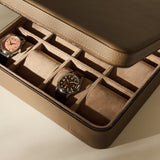 Truffle Taupe TAWBURY Fraser 12 Watch Case with a zippered closure and twelve interior compartments, two of which contain wristwatches.