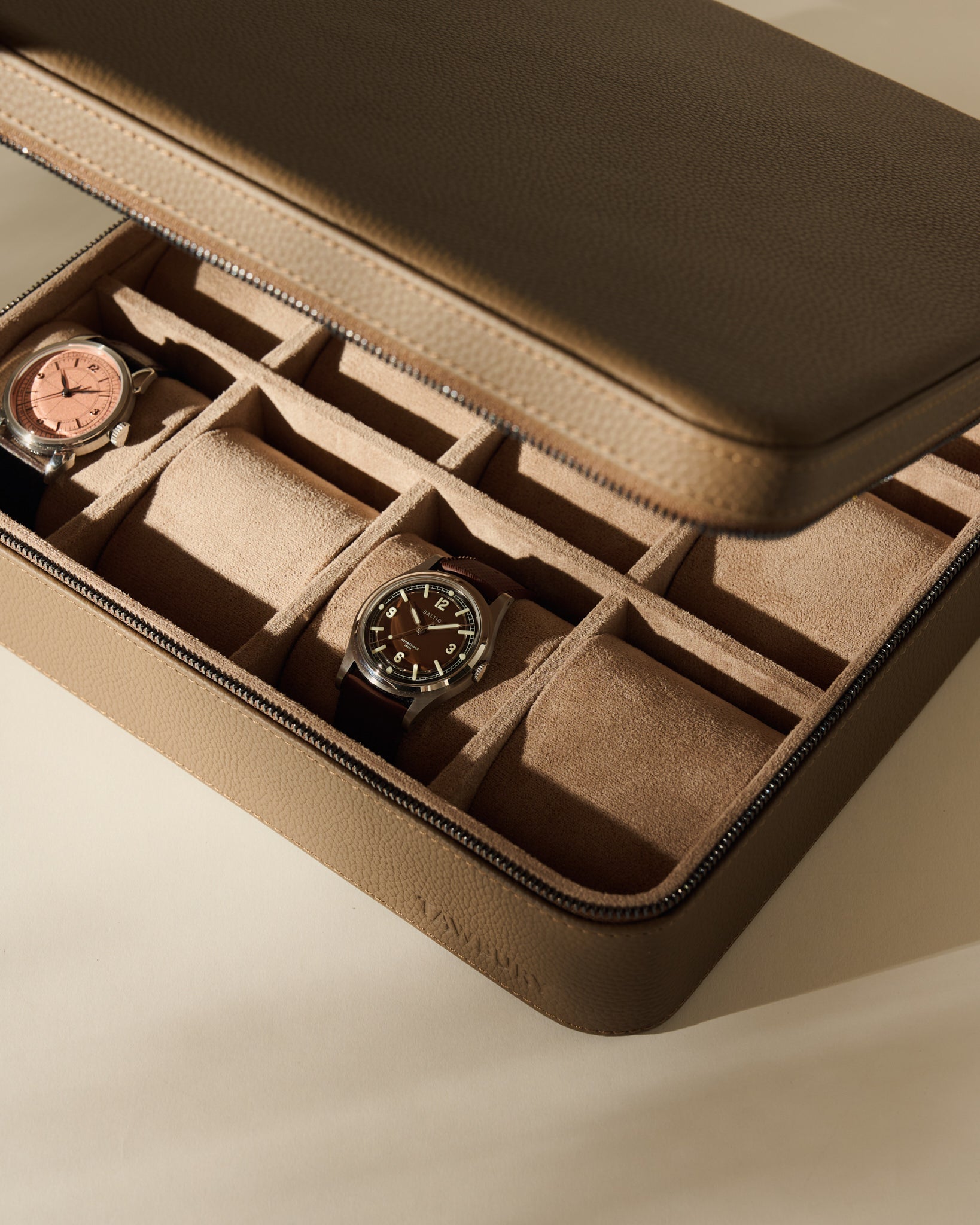 Truffle Taupe TAWBURY Fraser 12 Watch Case with a zippered closure and twelve interior compartments, two of which contain wristwatches.