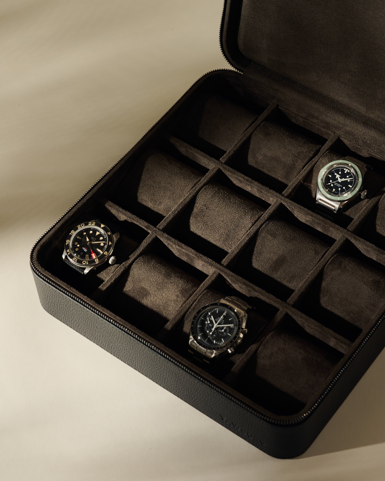 A TAWBURY Fraser 12 Watch Case - Midnight Black, a twelve-slot zippered leather watch box containing three wristwatches.