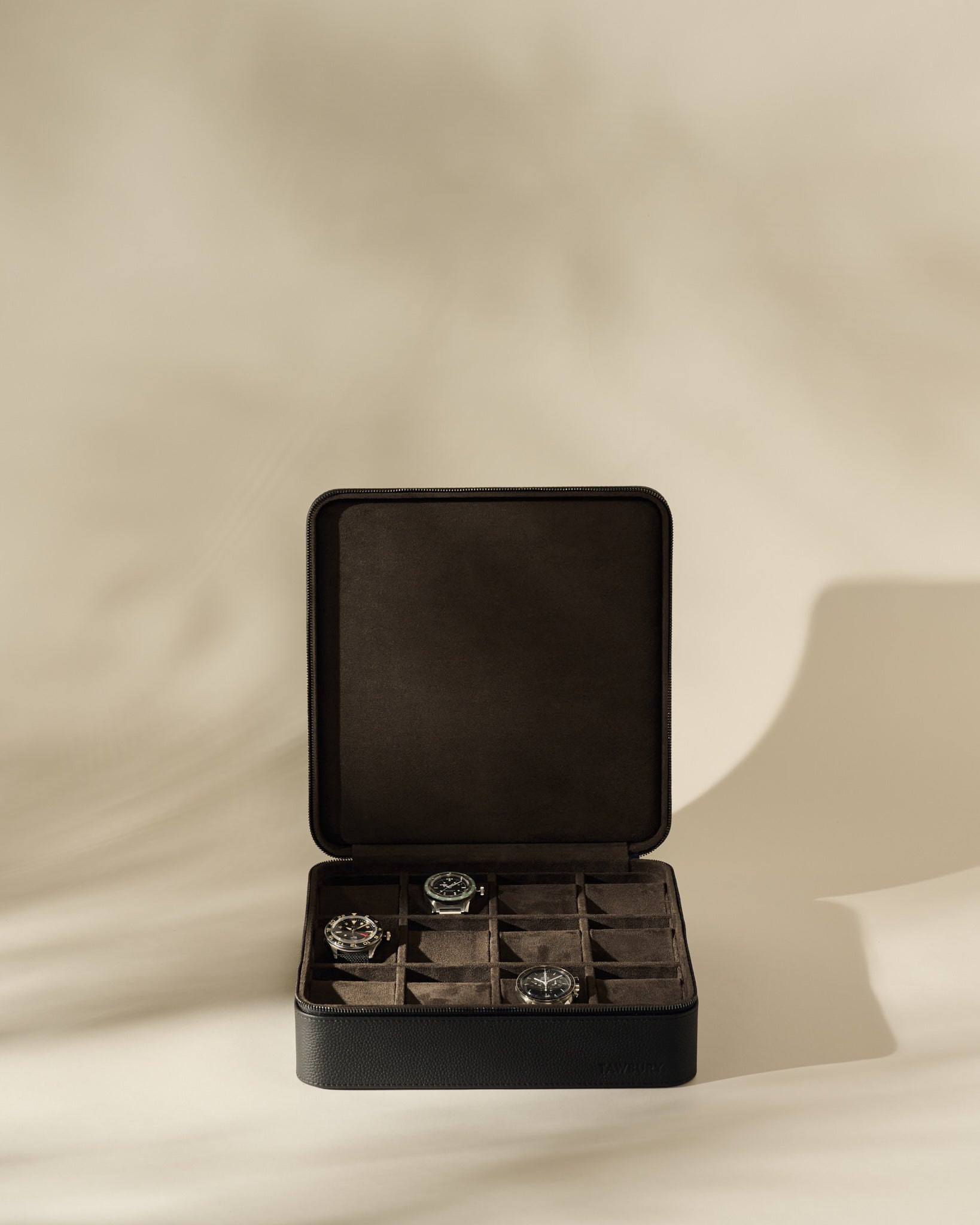 Open black TAWBURY Fraser 12 Watch Case - Midnight Black with twelve interior compartments, containing three wristwatches.