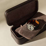 An open, dark brown Fraser 3 Watch Case - Espresso Brown with a cushioned interior holding one men’s chronograph wristwatch.