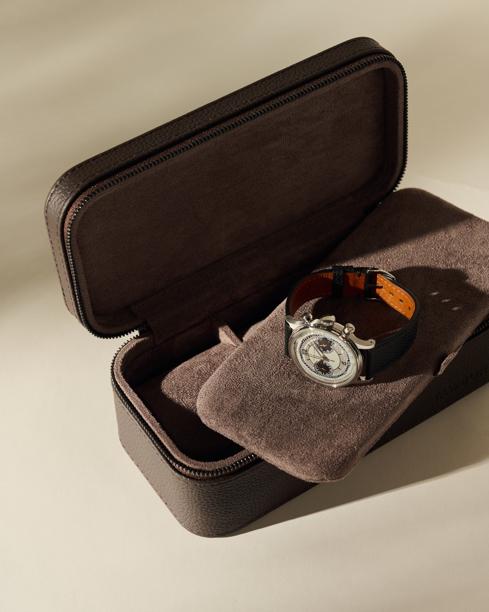 An open, dark brown Fraser 3 Watch Case - Espresso Brown with a cushioned interior holding one men’s chronograph wristwatch.