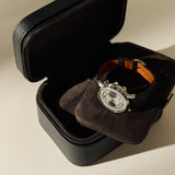 Open black leather TAWBURY Fraser 2 Watch Case - Midnight Black with a cushioned insert holding a silver chronograph wristwatch.