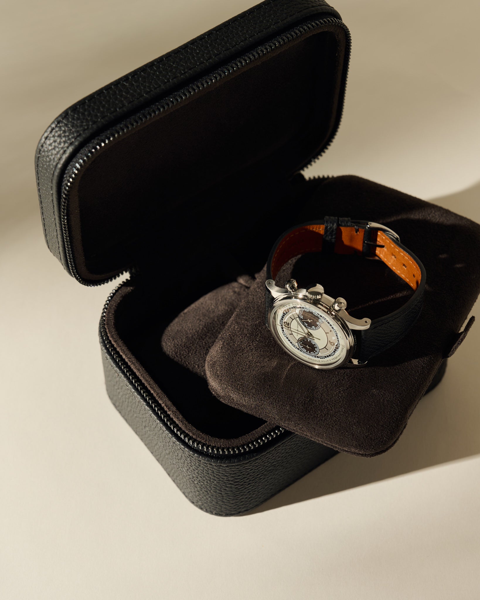 Open black leather TAWBURY Fraser 2 Watch Case - Midnight Black with a cushioned insert holding a silver chronograph wristwatch.