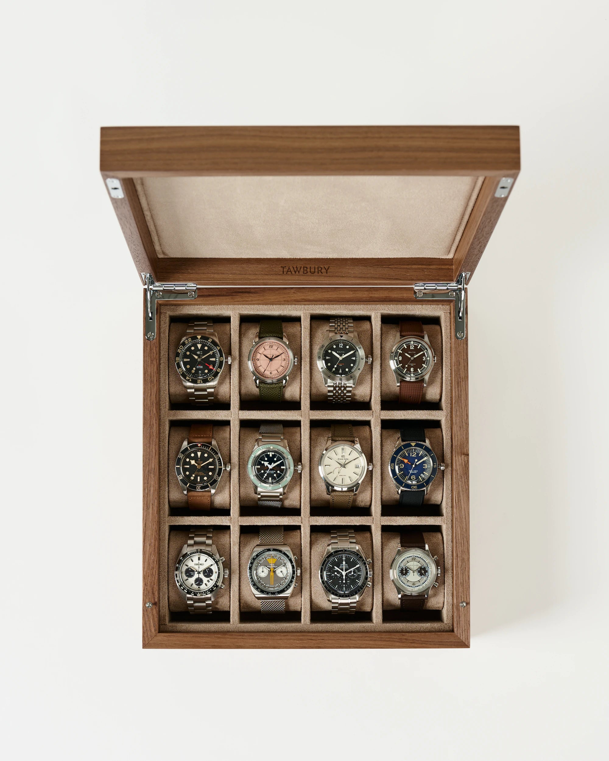 The TAWBURY Grove 12 Slot Wooden Watch Box in light walnut features a solid lid and organizes twelve wristwatches in three rows of four, each displayed against a stylish white background.