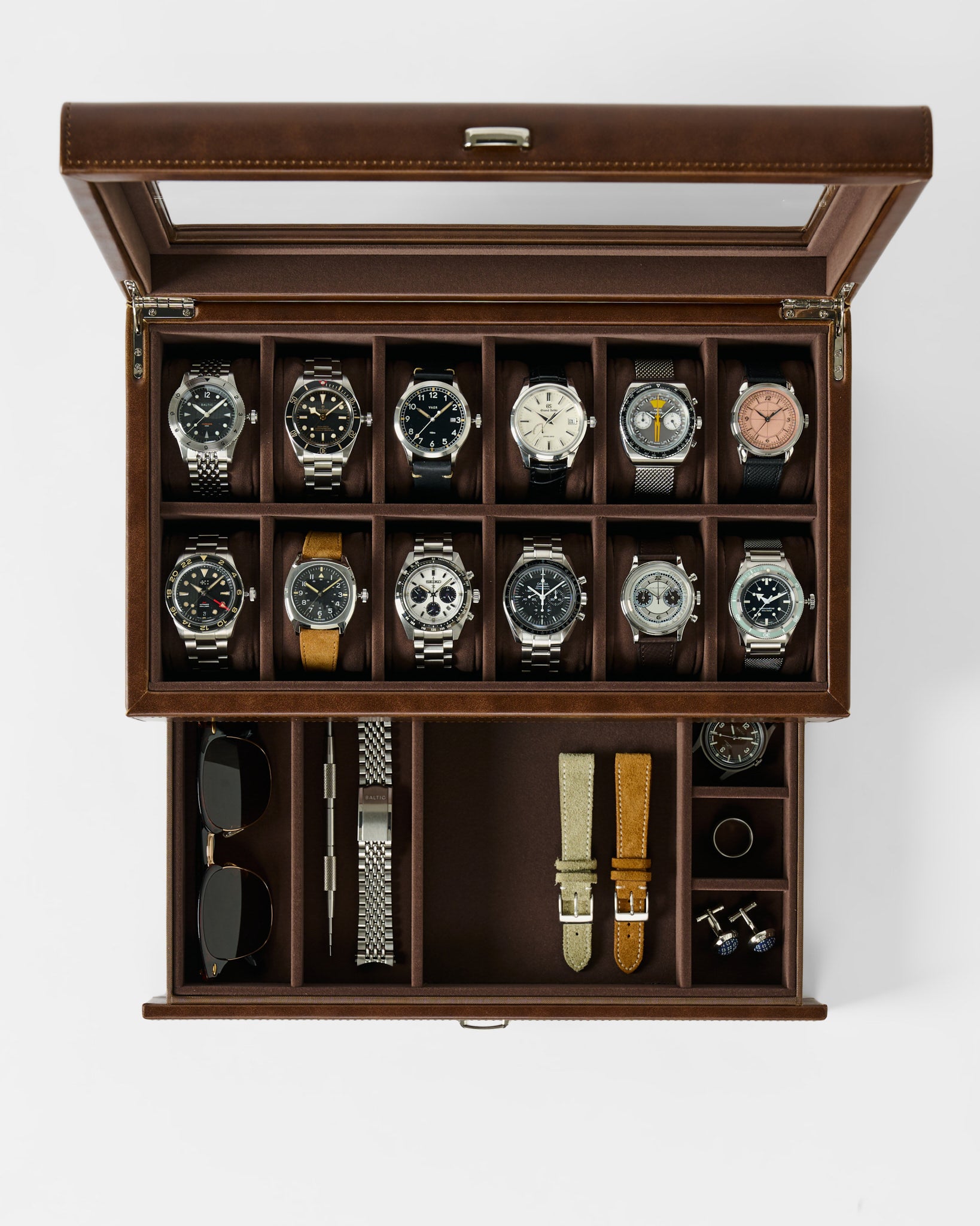 The TAWBURY Bayswater 12 Slot Watch Box with Storage in brown, shown from above, holds twelve watches, two pairs of sunglasses, watch straps, a metal bracelet, a watch tool, and cufflinks.