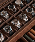 A collection of Bayswater 12 Slot Watch Boxes with Drawer - Brown by TAWBURY in a wooden storage box.