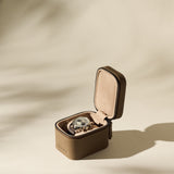 A wristwatch with a brown strap is displayed in an open TAWBURY Fraser 1 Watch Case - Taupe on a neutral background.