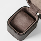 The TAWBURY Fraser 1 Watch Case - Brown features a textured leather exterior, zippered closure, and a soft cushioned insert—partially open to show the interior—making it ideal for elegant watch storage while traveling.