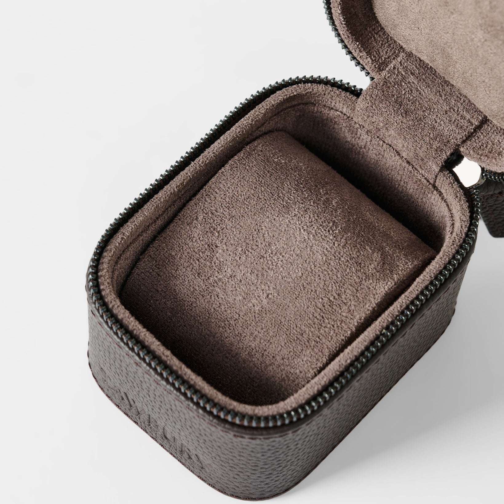 The TAWBURY Fraser 1 Watch Case - Brown features a textured leather exterior, zippered closure, and a soft cushioned insert—partially open to show the interior—making it ideal for elegant watch storage while traveling.