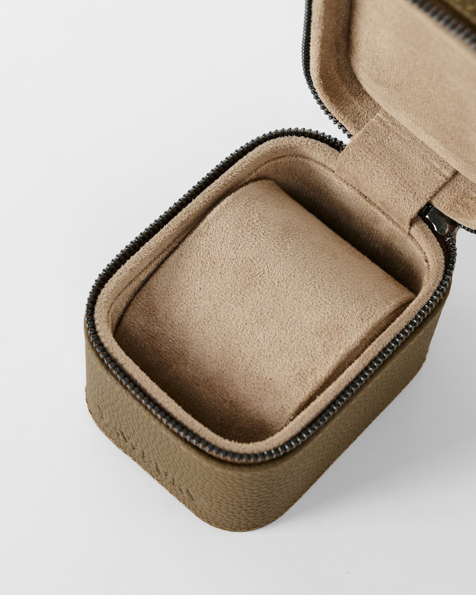 The TAWBURY Fraser 1 Watch Case in taupe features a textured fabric exterior, soft cushioned interior, and secure zipper closure. Shown open and empty.