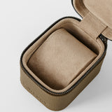 The TAWBURY Fraser 1 Watch Case in taupe features a textured fabric exterior, soft cushioned interior, and secure zipper closure. Shown open and empty.