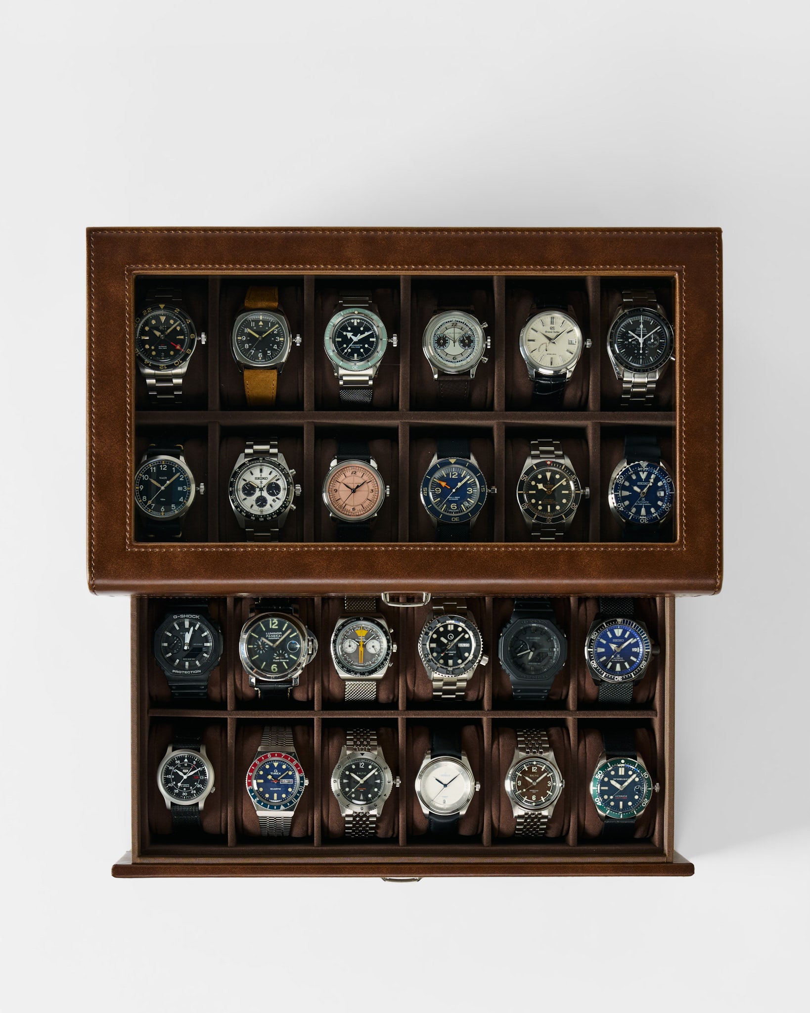 The TAWBURY Bayswater 24 Slot Watch Box with Drawer in brown is shown from above, featuring twenty wristwatches neatly stored in individual compartments against a white background.