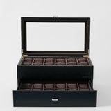The TAWBURY Bayswater 24 Slot Watch Box with Drawer in Midnight Black features a glass lid, two rows of padded slots for elegant watch display, and a drawer with additional empty slots.
