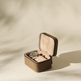 The Fraser 2 Watch Case - Taupe by TAWBURY, crafted in brown textured leather with a beige suede interior, is photographed on a neutral, softly lit background.