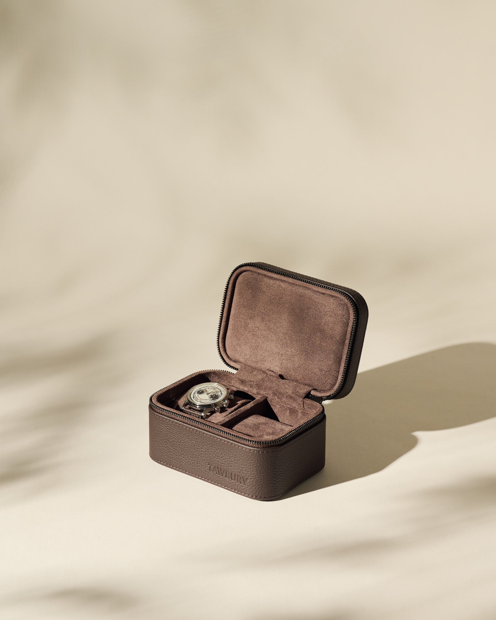 The TAWBURY Fraser 2 Watch Case - Brown is shown open with a single watch inside, set against a neutral beige background and subtle shadows.