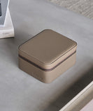 A Fraser 2 Watch Travel Case with Storage - Taupe designed for functionality and protection, sitting on a table.