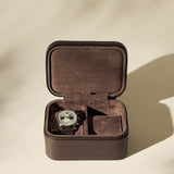 A wristwatch is displayed inside an open TAWBURY Fraser 2 Watch Case - Brown, with a second empty compartment.