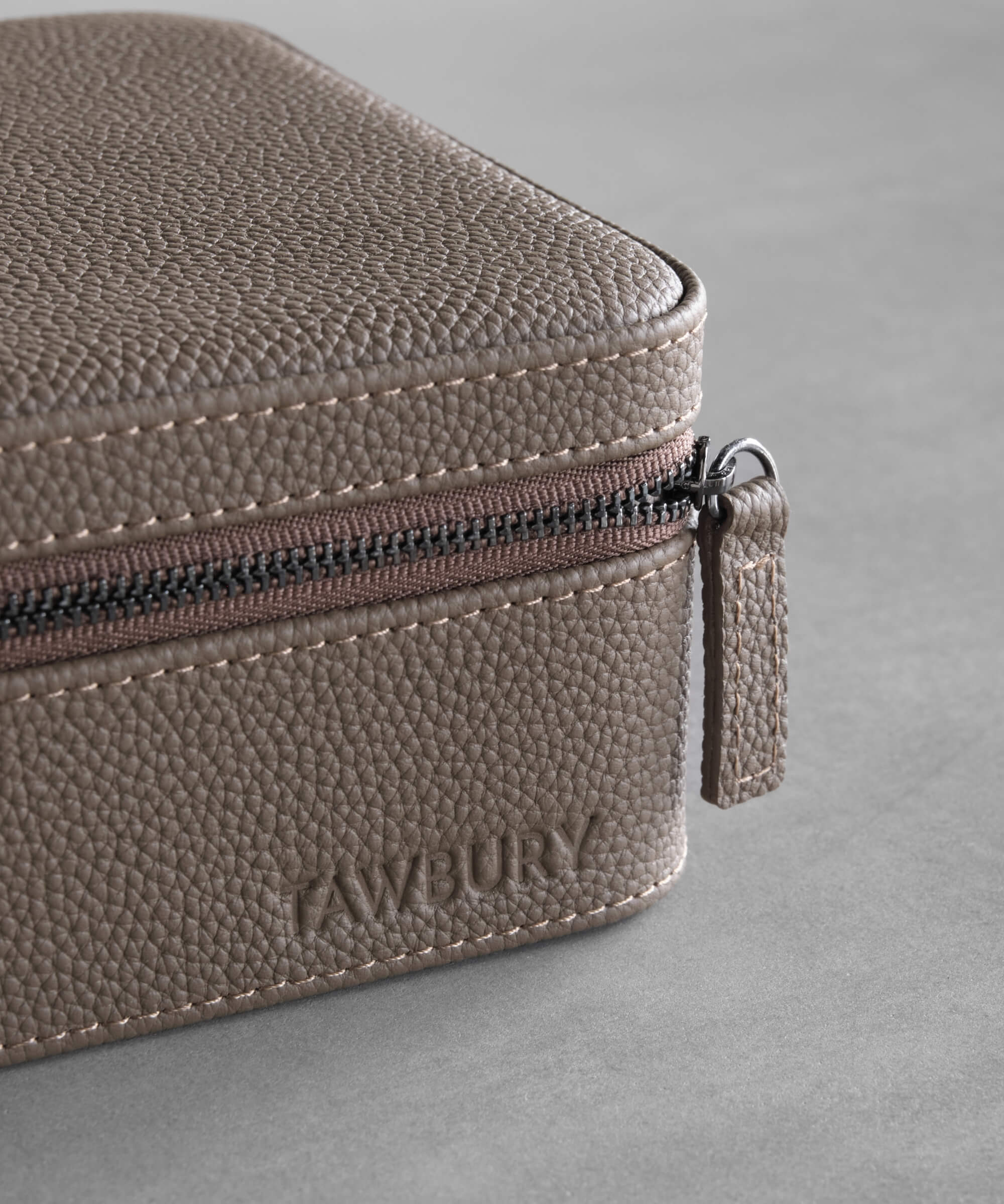 A TAWBURY Fraser 2 Watch Travel Case with Storage - Taupe leather travel case with a zipper for watch protection and functionality.