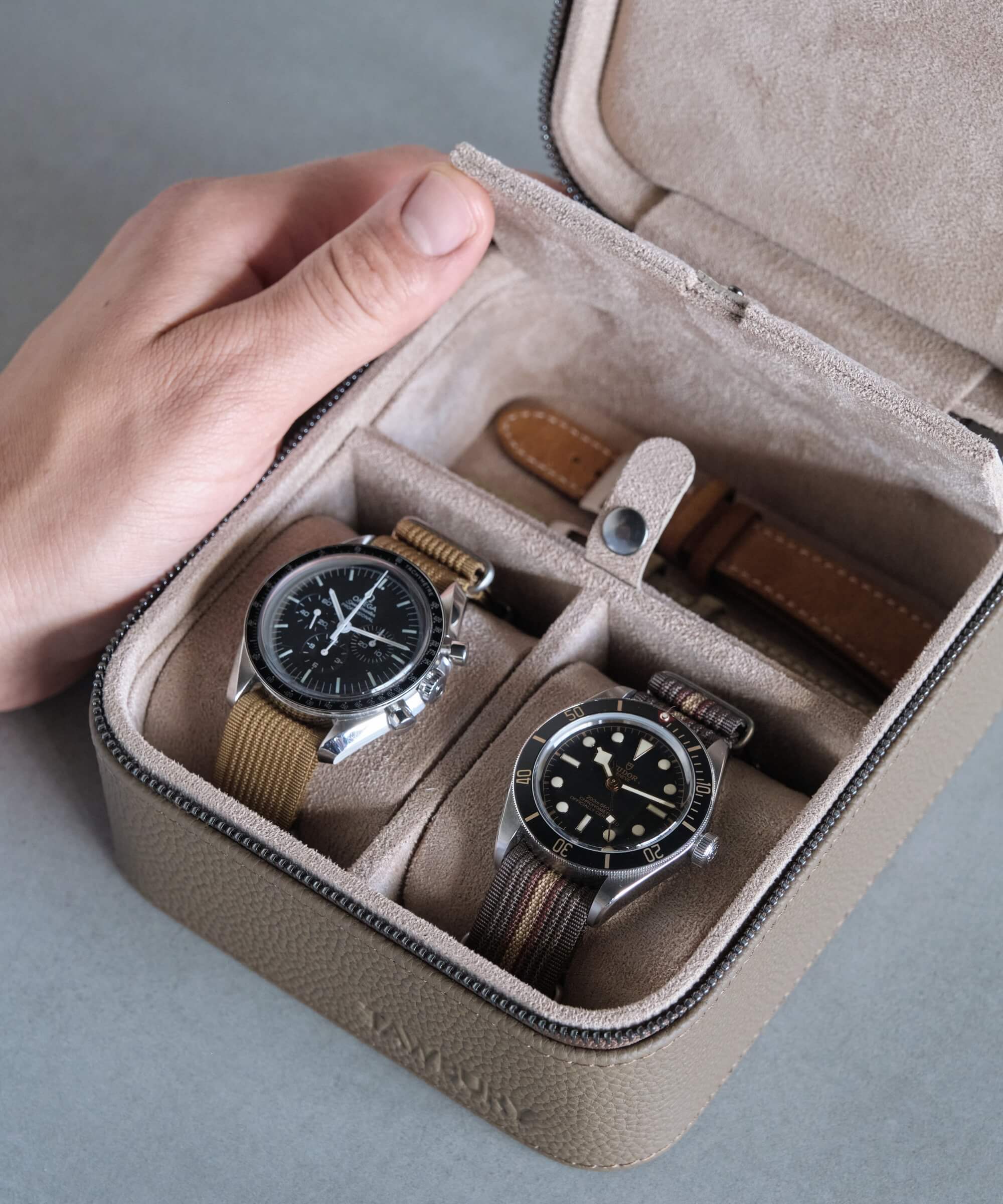 A person carrying two TAWBURY watches in a Fraser 2 Watch Travel Case with Storage - Taupe.